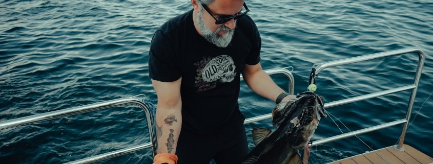 Guest reeling in a fresh catch during a fjord fishing tour near Bergen.