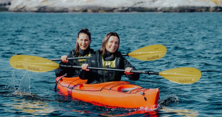 Group enjoying a peaceful kayaking experience with crystal-clear waters surrounding Bergen.